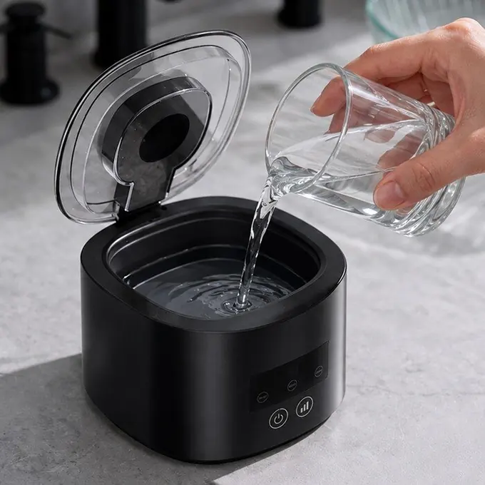 Plain water poured into the stainless steel tank of the DentaSonic cleaner